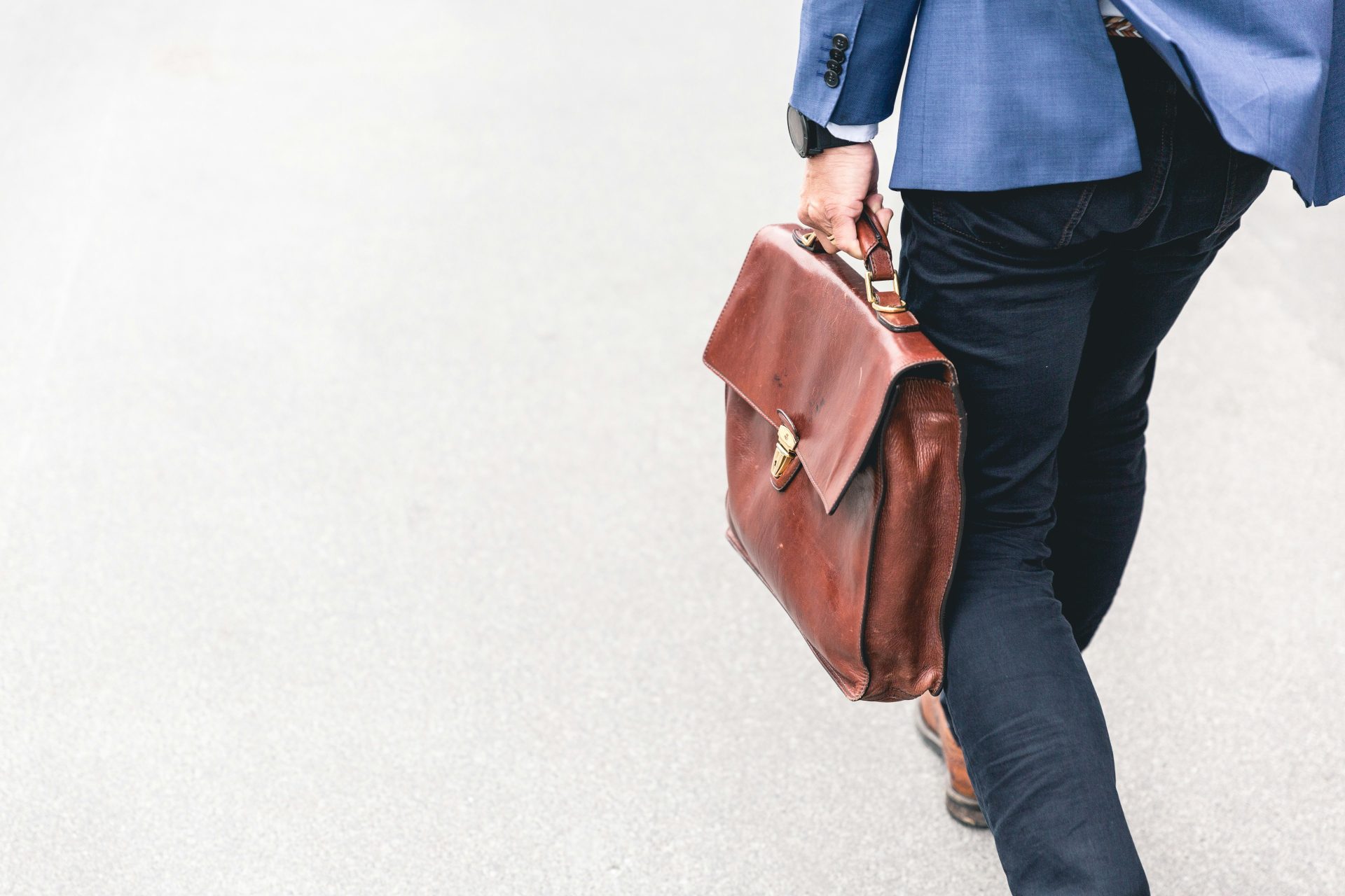 Person, die zu Fuß mit brauner Ledertasche